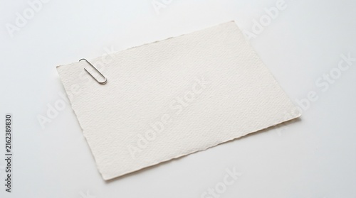 Blank paper card with metal paper clip on white background