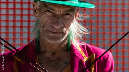Elderly performer portrait with green hat and magenta jacket holding crossed whips for theatrical circus poster and dramatic banner background