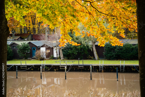 Calm river surrounded by colorful autumn trees in Skåne, Sweden. Peaceful seasonal landscape, creating a scenic atmosphere for outdoor recreation and travel.