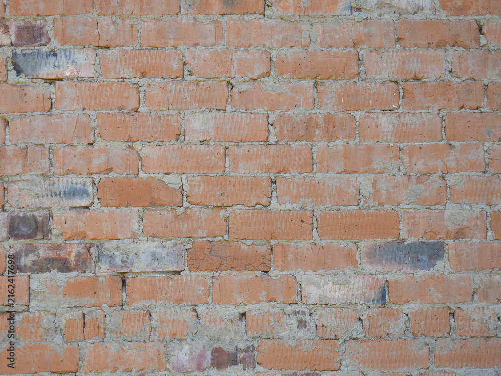 Fototapeta premium Old weathered yellow and red brick wall background with irregular masonry texture