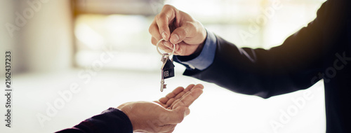Obraz na płótnie close up view hand of property realtor landlord giving key house to buyer tenant