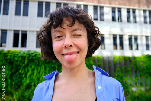 Фотография headshot of Woman winking and sticking out tongue playful expression
