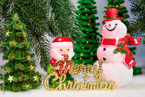 A dollar bill with a red ball and Santa Claus among green Christmas trees