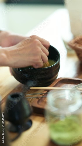Traditional Japanese Matcha Tea Ceremony Preparation with Chasen Whisk in Black Ceramic Bowl