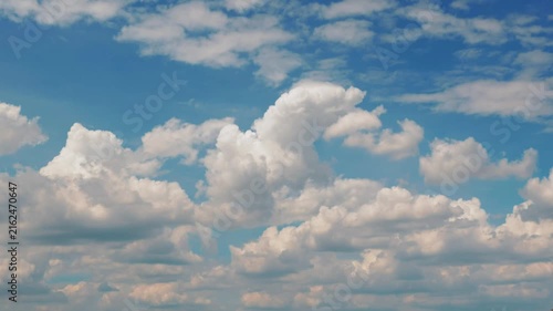 White puffy clouds drifting across a bright blue sky during a sunny afternoon capturing nature in motion