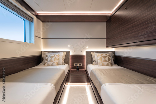 Bild auf Leinwand Interior of a superyacht guest cabin, with double bed, decorative pillows and mo