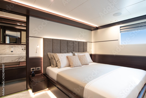 Obraz na plátně Interior of a modern superyacht guest cabin, with double bed, decorative pillows