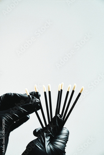 Lash technician holding a fan of white-tip applicator brushes