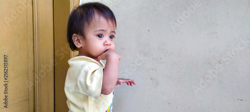 Fotografie Joyful baby girl showing delightful emotion on porch