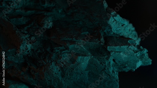 Rock edge with teal lighting and dark abstract natural background