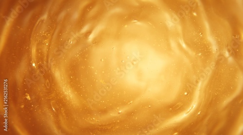 Golden honey texture close-up with warm glowing light and smooth liquid surface for food design