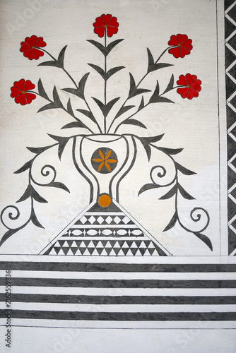 Close-up of Genoese floral symbols with red blossoms in a vase on a house facade in Pyrgi, Chios