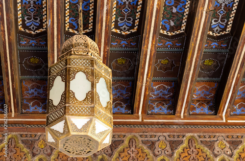 Fotografie Traditional Brass Lantern Suspended Beneath an Elaborately Painted Wooden Ceilin