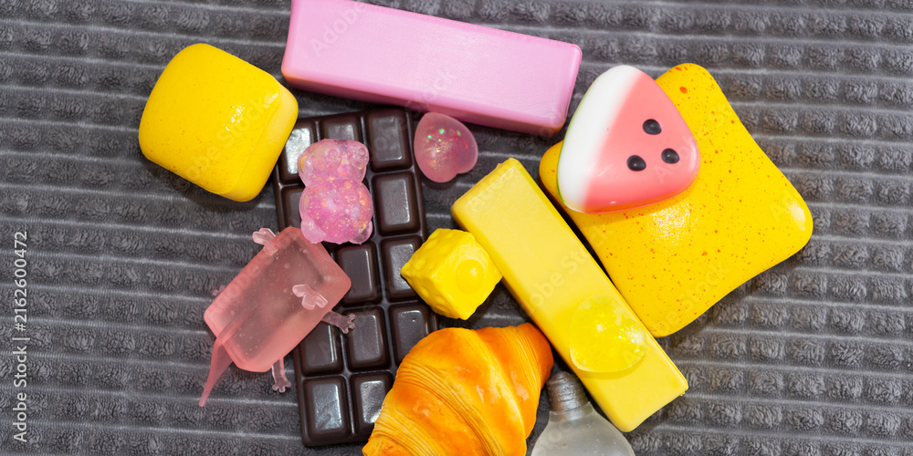 Naklejka premium Colorful squishy toy assortment of candy shaped silicone pieces on textured mat for background and flatlay banner design