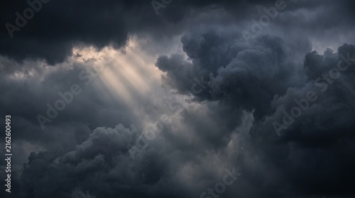Photography Storm clouds fill the dark sky as sunbeams shine through the dramatic atmosphere