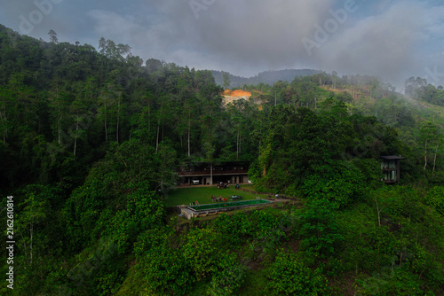 Aerial View of Modern Tropical Forest Resort Villa, Swimming Pool, and Misty Mountain Landscape