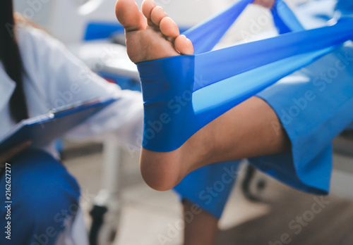 Doctor checks Asian senior woman patient after knee replacement operation in hospital room. Nurse examines leg after surgery. Medicine health treatment therapy healthcare concept