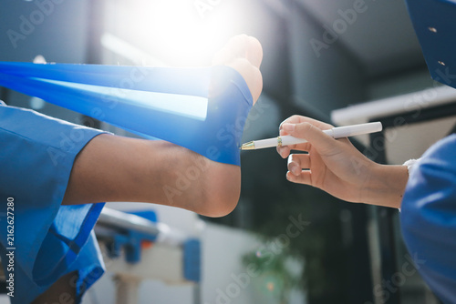 Doctor checks Asian senior woman patient after knee replacement operation in hospital room. Nurse examines leg after surgery. Medicine health treatment therapy healthcare concept