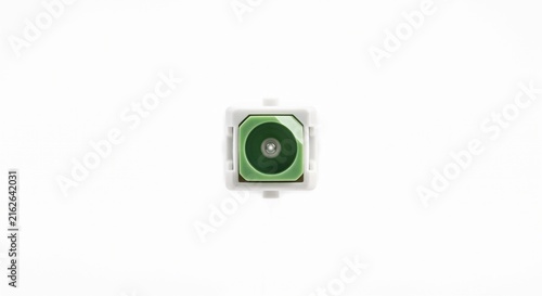 Extreme macro of a bare SC/APC fiber optic connector tip. Features an angled green ceramic ferrule and glass core. Telecommunications hardware on white.
