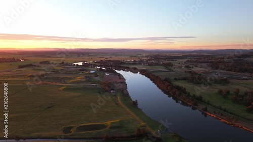 Hunter River curves across rural Hunter Valley farmland and riverine path beneath sunset light in New South Wales, aerial overview, Australia