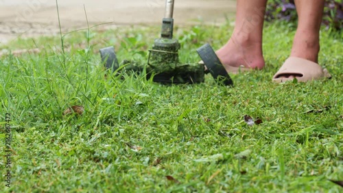 Small Electric Lawn Mower with Tank Tracks Cutting Grass in Garden