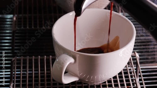 Close-up of espresso pouring from the coffee machine into a coffee cup. Professional coffee brewing	