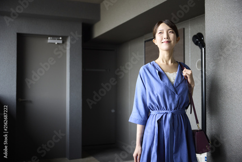 玄関を出て歩き始める女性
