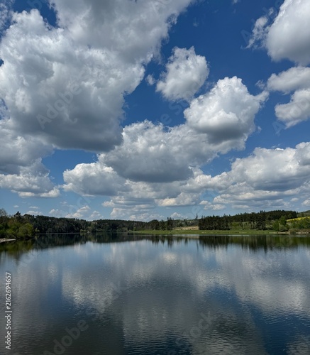 Calm lake reflecting clouds and blue sky