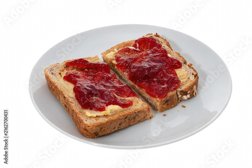 Bild auf Leinwand Two Slices of Toasted Seeded Bread with Butter and Red Jam on a White Plate