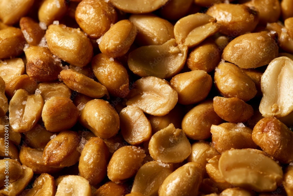 Fototapeta premium Roasted peanuts are displayed on a surface after being cooked and salted in a kitchen setting