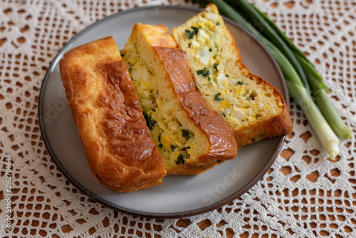 A photo of a jellied pie with green onions and a boiled egg.