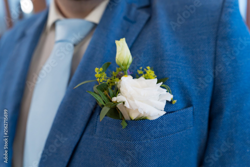 Konstfotografi Elegant wedding corsage with white flower and green leaves in a pocket of a blue gentleman suit