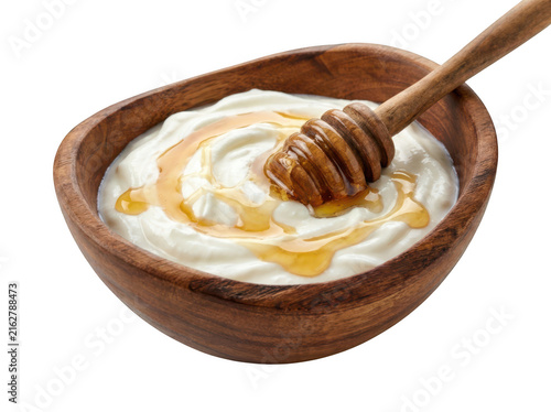 Bowl of fresh creamy yogurt with honey drizzle and wooden dipper isolated on transparent background