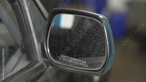 A close up of a dusty passenger side wing mirror.