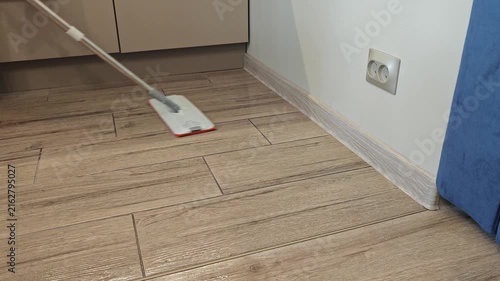 Cleaning the floor in a kitchen area with a mop and bucket