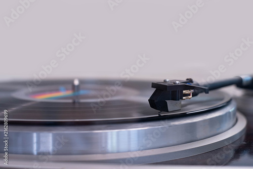Photography Close-up of a vinyl record playing on a turntable with a precision tonearm and stylus, capturing analog music, vintage audio technology, high fidelity sound, nostalgia, and classic entertainment