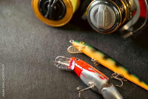 Canvastavla Artificial fishing lures and spinning reel on dark background The Concept of ang