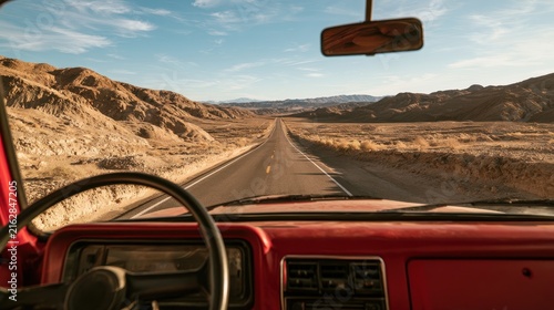 Scenic View from Vintage Truck on Desert Highway with A Vast Landscape of Mountains and Clear Blue Sky in a Remote Area