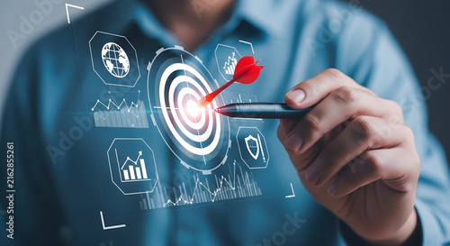 Businessman using a digital pen to hit the target on a holographic interface for strategic business growth and financial planning analysis