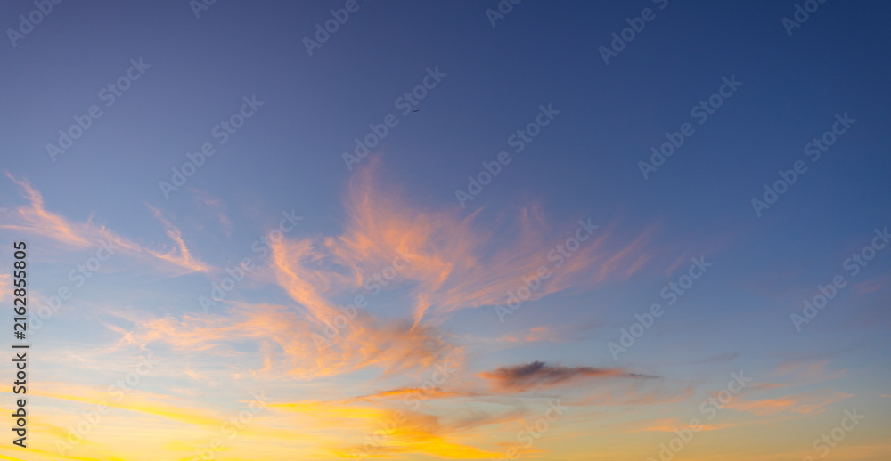 Obraz premium Vibrant Sunset Sky with Dramatic Purple and Orange Clouds,A stunning and vibrant sunset sky, featuring a beautiful blend of deep purple, blue, and fiery orange clouds. The dramatic cloud formations.