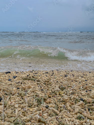 Konstfotografi Ocean Wave Breaking on a Coral Rubble Beach Under Cloudy Sky