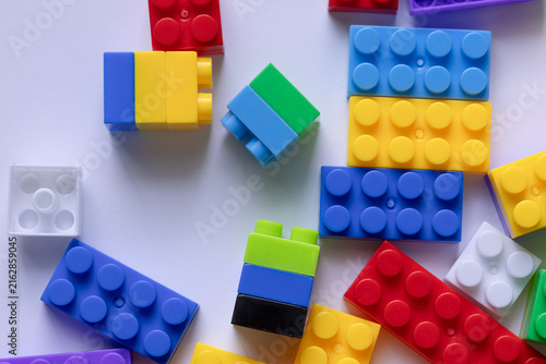 Canvastavla Colorful plastic building blocks toy pieces scattered on a white background,Top