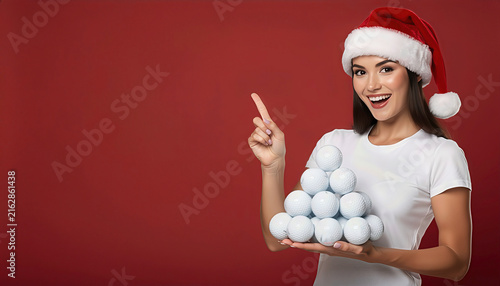 Happy young woman in santa hat holding golf balls, space for text , Christmas golf concept 