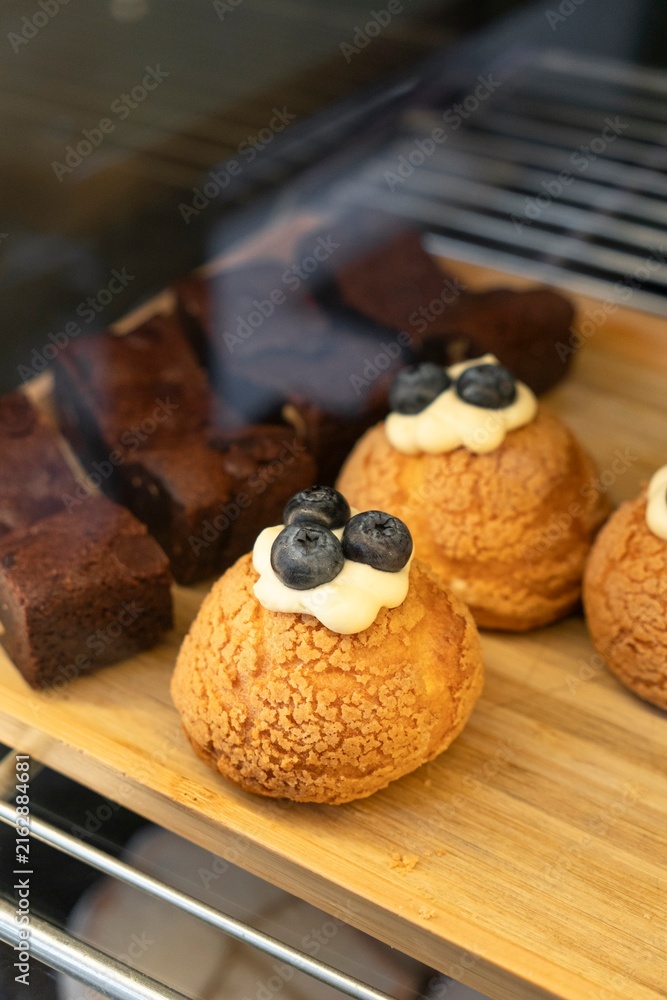 Fototapeta premium Choux Pastries Topped with Cream and Fresh Blueberries