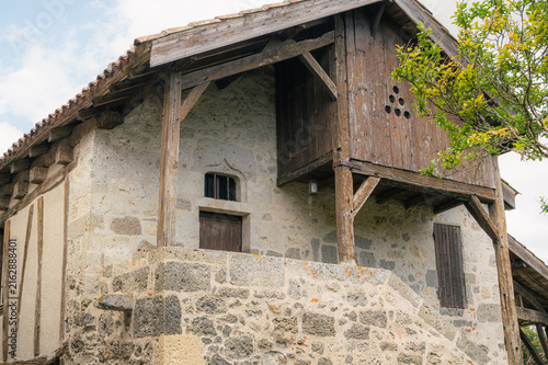 Bild auf Leinwand Ferme traditionnelle en pierre avec grange à pans de bois, Bazens
