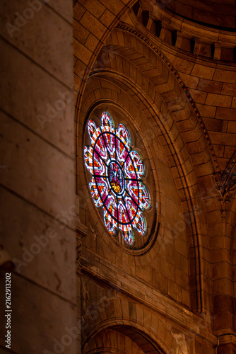 Photography looking up at stained glass window with golden soft dim light in the sacre-coeur