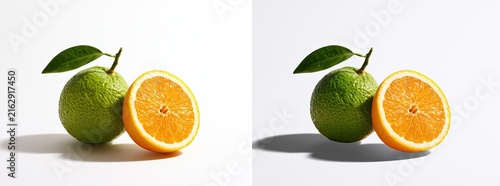A whole green orange and a half orange with bright orange pulp and seeds on a white background.