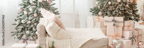 Foto Christmas interior with two decorated trees, glowing lights, wrapped presents, and cozy armchair