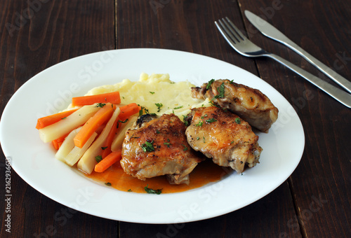 Roasted chicken thighs served with creamy mashed potatoes and steamed root vegetables