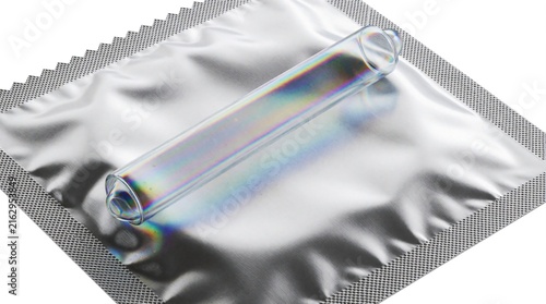Transparent condom lies on silver foil wrapper. Clear prophylactic protection sits on metallic packaging. Safe sex product for birth control, disease prevention. Single use contraceptive item shown